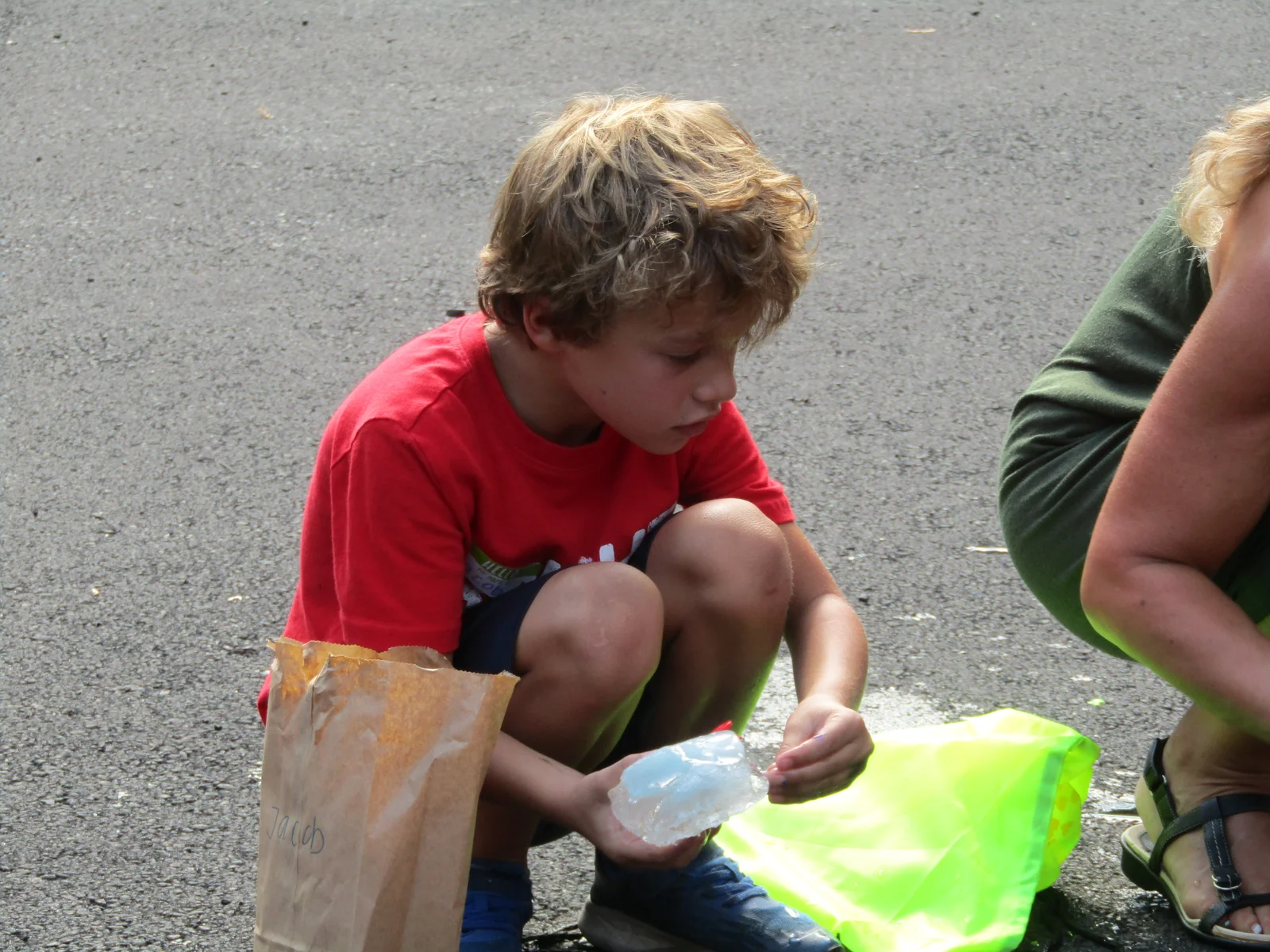 A volunteer helping a child with a craft project at camp