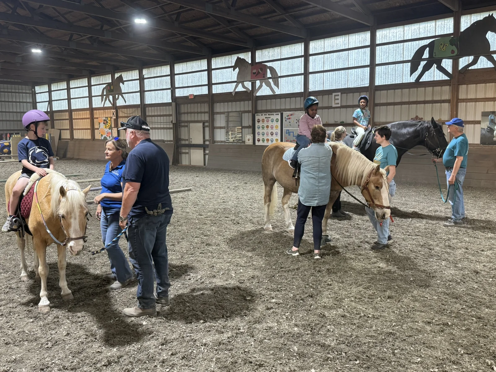 A Hands Holding Hearts family spending time with the therapy horses at Special Equestrians