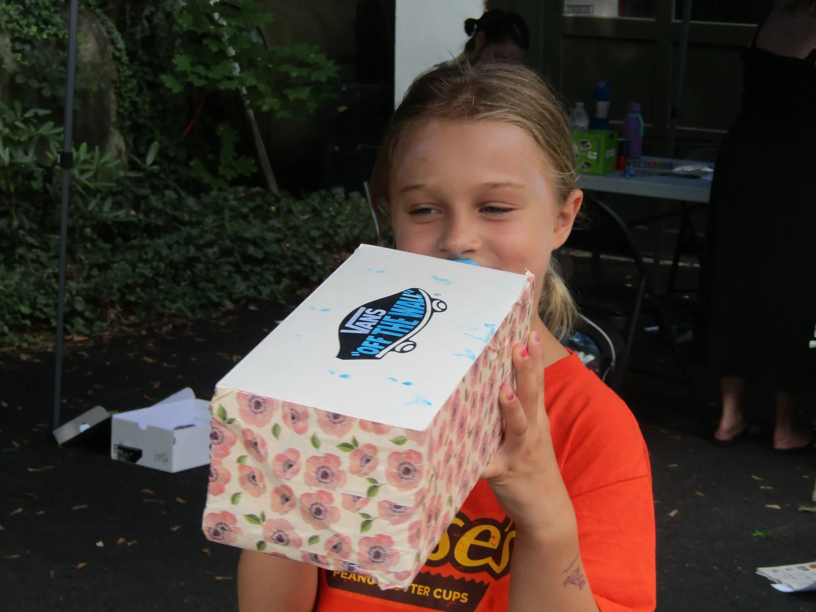 A smiling girl holding a decorated memory box she made