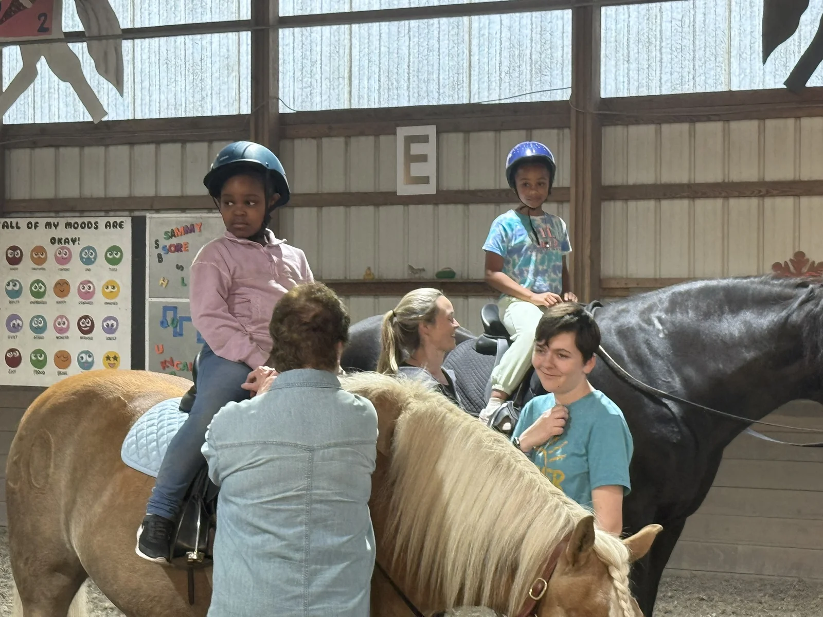 A Hands Holding Hearts family spending time with the therapy horses at Special Equestrians